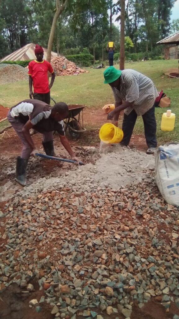 Workers mixing concrete by hand during construction