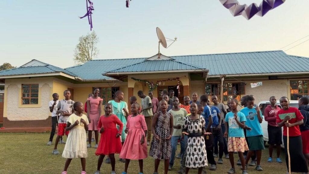 Children singing together in front of the orphanage home