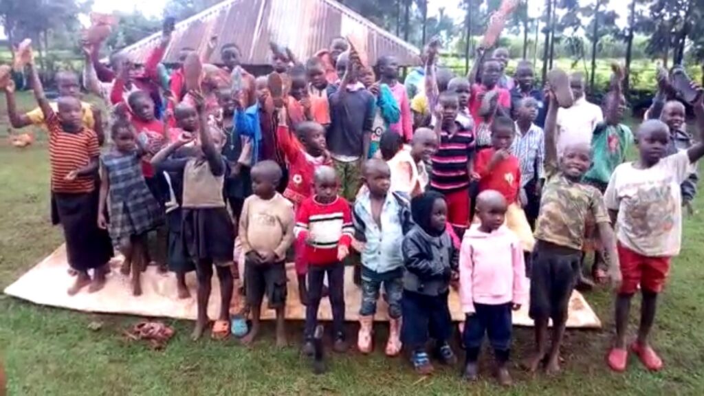 Children gathered in front of the original shelter